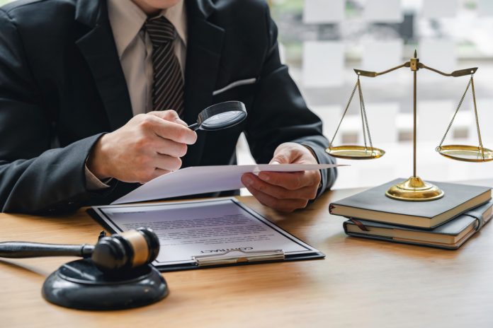 Attorney,Or,Judge,Sitting,At,Desk,,Holding,Magnifying,Glass,And